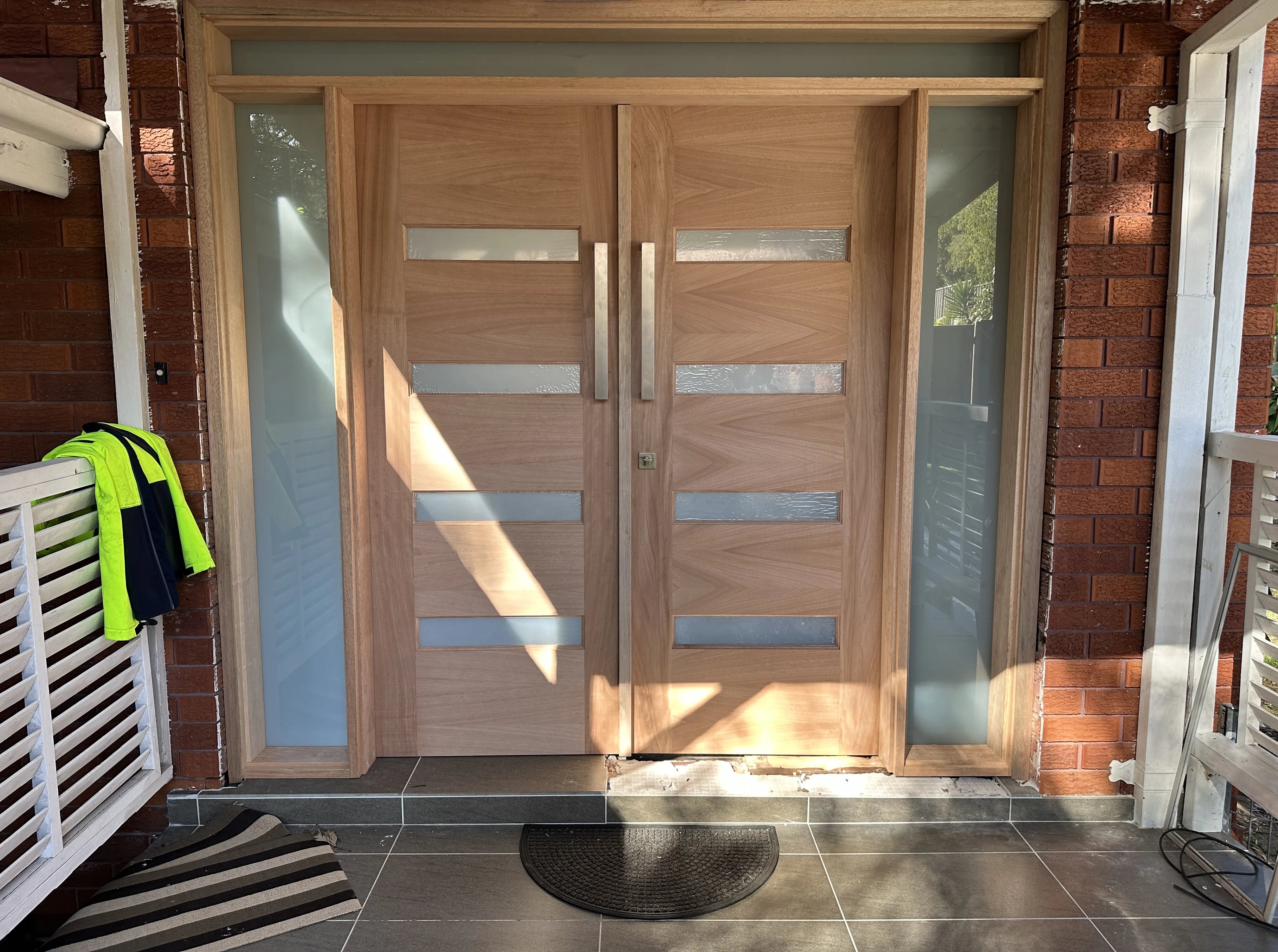 External double doors installed in Lugarno, Sydney. Frosted glass fixed panels on either side of doors and top fixed panel above the double doors.