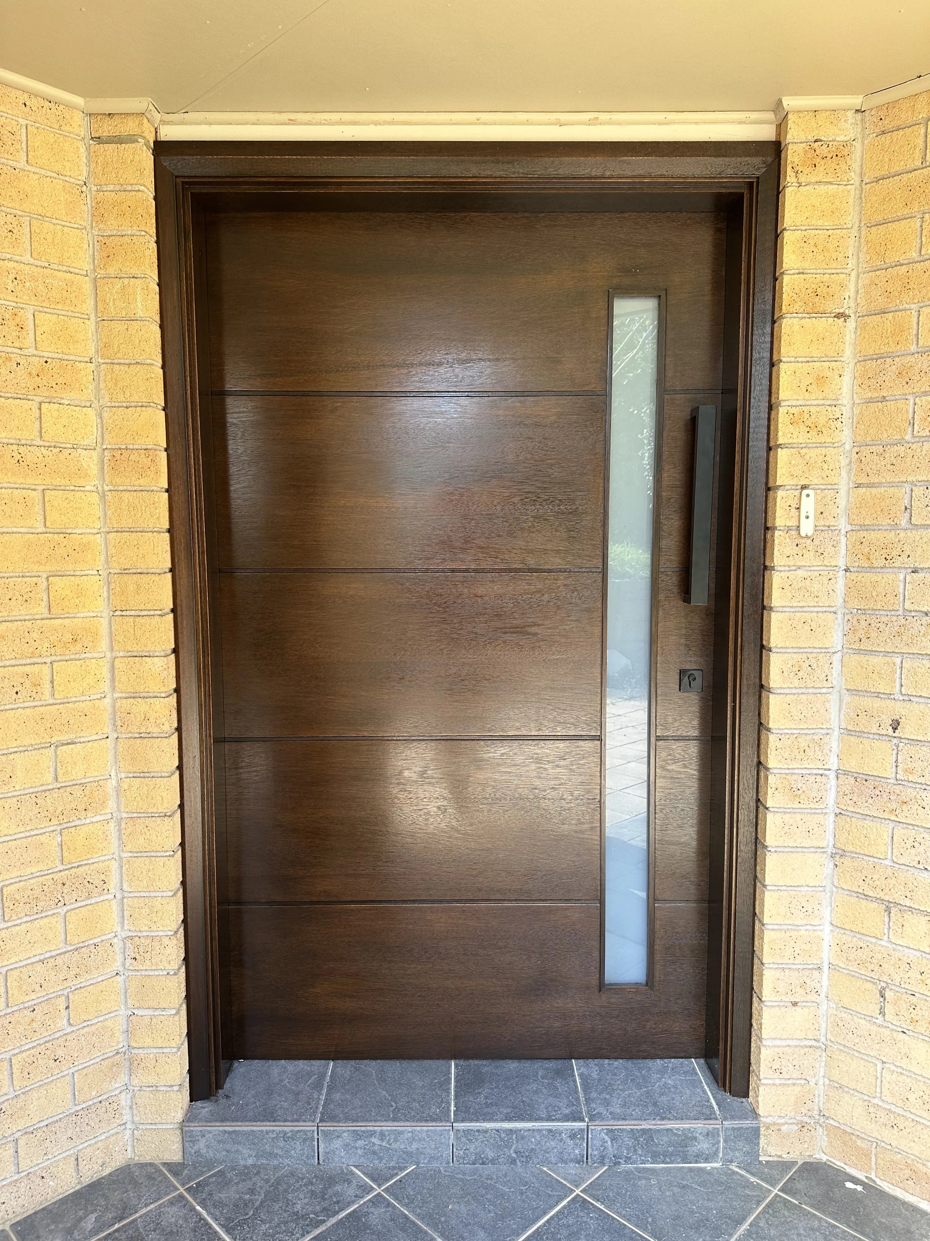 Modern stained chocolate walnut front door installed in a Sydney home, showcasing contemporary design and rich timber tones